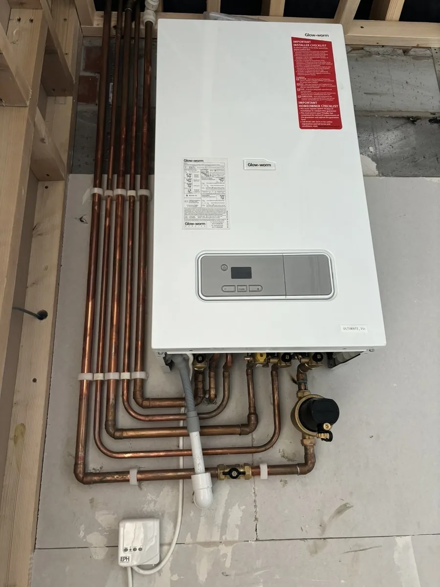 Glow-worm Ultimate 35c combi boiler fitted on a new stud wall, with neatly clipped copper pipework, isolation valves and a magnetic system filter below